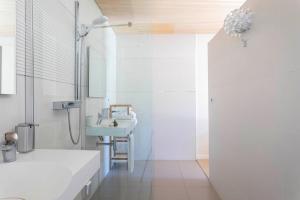 een witte badkamer met een wastafel en een douche bij Bien Loin d'Ici Spa B&B in Nîmes
