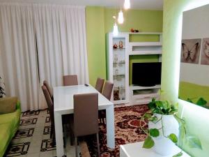 a living room with a white table and a television at Via Genova Apartment in Olbia