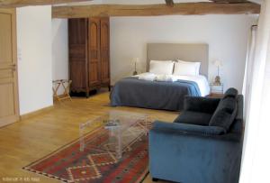 a bedroom with a bed and a couch at Maison Saint-Pé (Gers) in Béraut
