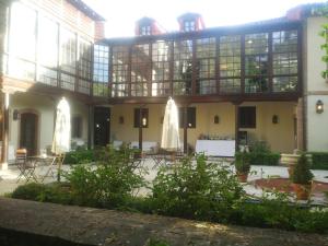 un edificio con un patio con mesas y sillas en Posada Real Casa de Tepa en Astorga