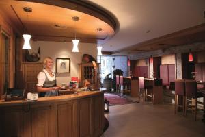 Eine Frau steht in einer Bar in einem Restaurant. in der Unterkunft Hotel Montana in Sankt Anton am Arlberg