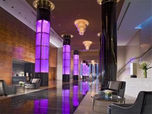 a lobby with black columns and purple lighting at Grand Millennium Beijing in Beijing