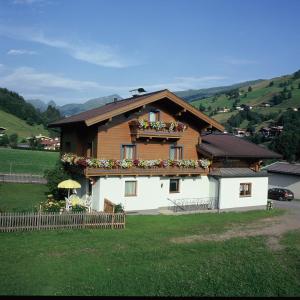 a house with flowers on the front of it at Ski & Bike Pension Maria in Saalbach-Hinterglemm