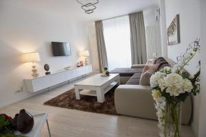a white living room with a couch and a table at Metropole Apartments Old Town in Bucharest