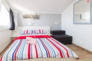 a bedroom with a bed with a pink pillow on it at Guest House Berto in Crikvenica