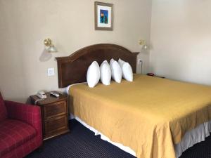 um quarto de hotel com uma cama e uma cadeira vermelha em Knights Inn Harrisonville em Harrisonville