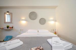 a bedroom with a bed with towels on it at Africanis Suites in Schinoussa +127 photos