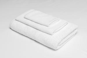 una pila de toallas blancas en un fondo blanco en Knights Inn Harrisonville, en Harrisonville