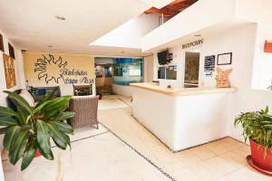 un restaurant avec un comptoir et des plantes dans une salle dans l'établissement Hotel Suites Ixtapa Plaza, à Ixtapa