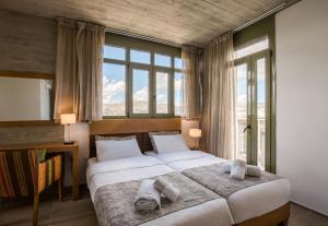 a bedroom with two beds and a large window at Anna Boutique Villas in Mixórrouma +83 photos