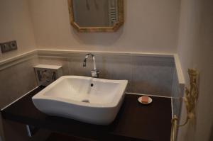a white sink in a bathroom with a mirror at Ellesmere in Bazens +7 photos
