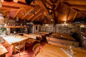 a restaurant with wooden tables and chairs and a stone wall at Guest House Berto in Crikvenica