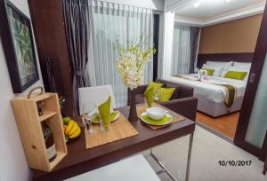a living room with a table and a bed at The Aristo by Holy Cow, studio, mountain view in Surin Beach