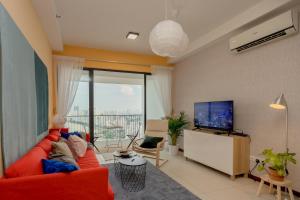 a living room with a red couch and a flat screen tv at The Landmark Condo, by Sanguine in George Town