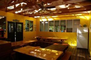 a dining room with wooden tables and a refrigerator at Sven's Basecamp Hostel in Fairbanks