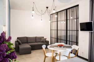 a living room with a couch and a table and chairs at Bolshaya Arnautskaya Apartment in Odesa