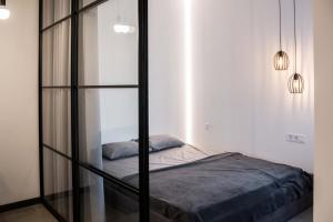 Bett in einem Zimmer mit Glaswand in der Unterkunft Bolshaya Arnautskaya Apartment in Odessa