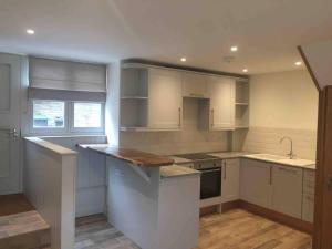 Stans Place Self Catering Cottage في مالمسبيري: مطبخ بخزائن بيضاء ومغسلة