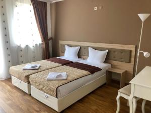 a bedroom with a bed with two towels on it at Family Hotel Ring & Thermal in Kyustendil