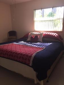 a bedroom with a bed with a red blanket and a window at Water FUN! poolPIERkayaksCANOE MotorBoatRENTALpets in Englewood