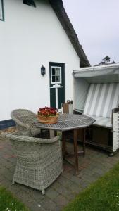 einen Tisch und Stühle mit einer Obstschale darauf in der Unterkunft Reetdach Friesenhof Süderende in Westerland