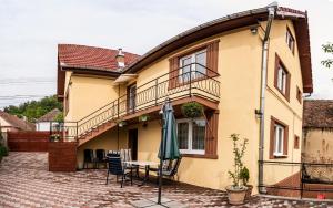 a house with a patio with a table and an umbrella at Gabi's Home #2 in Sighişoara