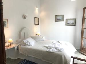 Un dormitorio con una cama blanca y un escritorio con dos lámparas. en Bungalows Svoronos, en Naousa