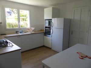 eine Küche mit weißen Geräten und einem weißen Kühlschrank in der Unterkunft Ti Moutik in Brignogan-Plage