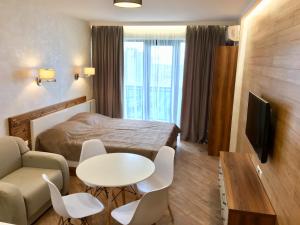 a hotel room with a bed and a table and chairs at Coast Batumi Apart Hotel in Batumi