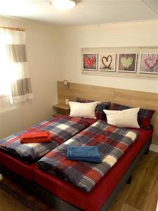 a bedroom with a large bed with a plaid blanket at Allgäu-Chalet in Buchloe
