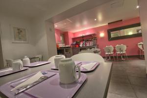 a dining room with pink walls and a table and chairs at Timhotel Paris Gare de Lyon in Paris