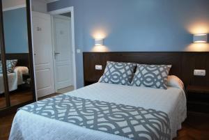 ノイアにあるHotel Restaurante Elisardoのベッドルーム1室(青い壁のベッド1台、鏡付)
