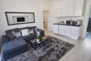 a living room with a blue couch and a kitchen at Metropole Apartments Old Town in Bucharest