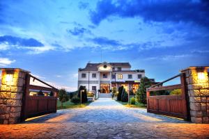 a large house with a gate and a driveway at Hotel Aria in Podgorica