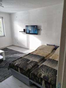 - une chambre avec un lit et une télévision murale à écran plat dans l'établissement Apartment LejlaM, à Sarajevo