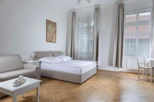 a white living room with a couch and a table at Three Golden Crowns Apartments in Prague