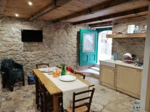 a kitchen with a table and chairs and a kitchen with a table and a kitchen at La casa di Duilia in Fornelli