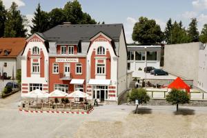 un edificio con mesas y sombrillas delante en Hotel Kašperk, en Kašperské Hory