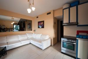 a living room with a white couch and a kitchen at Aphrodite - Beachfront House - Recently renovated in Glyfada