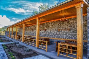 a building with wooden columns and a stone wall at Lara Hotel in Goris