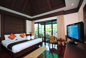 a bedroom with a bed and a television in a room at Aonang Orchid Resort in Ao Nang Beach +73 photos