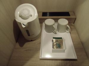 a table with two mugs and a watch on it at Hotel Il Fiore Kasai in Tokyo