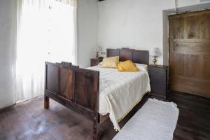 a bedroom with a bed with yellow pillows on it at A Fonte das Bodas in Samos