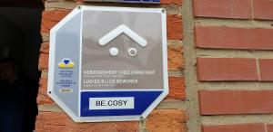 a sign on the side of a brick wall at Be.Cosy in Brussels