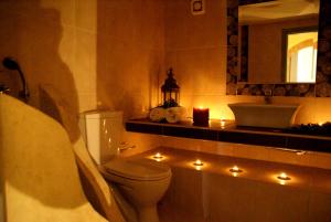 a bathroom with a toilet and a sink with lights at Celestia Traditional Houses in Keramoto