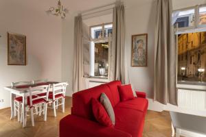 un soggiorno con divano rosso e tavolo di Three Golden Crowns Apartments a Praga