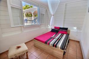 a bedroom with a bed and a window at Villa Cattleya 4 chambres, villa avec piscine privée et grande terrasse couverte in Le Vauclin +14 photos