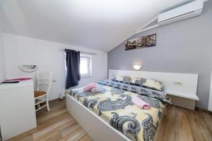 a bedroom with a bed and a desk in it at Guest House Berto in Crikvenica