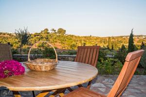 a wooden table with a basket of flowers on a patio at Celestia Traditional Houses in Keramoto