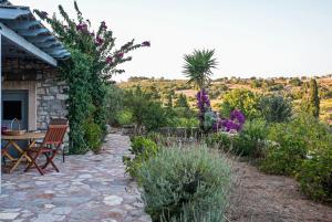 a garden with a table and chairs and flowers at Celestia Traditional Houses in Keramoto